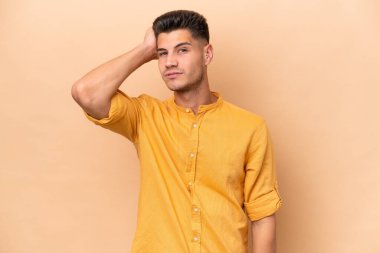 Beyazlı genç bir adam bej arka planda izole edilmiş ve hayal kırıklığı ifadesi var.