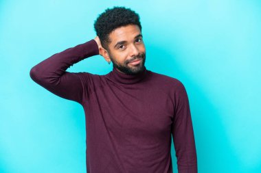 Genç Brezilyalı bir adam mavi arka planda soyutlanmış, hayal kırıklığı dolu ve anlamayan bir ifadeyle