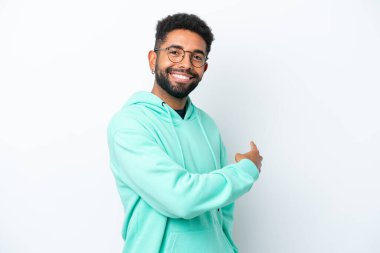 Beyaz arka planda izole edilmiş genç Brezilyalı adam geriye doğru işaret ediyor