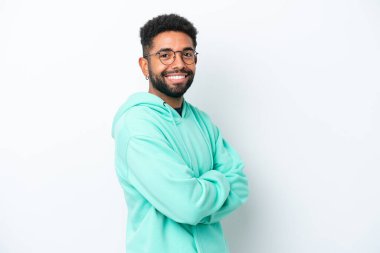 Genç Brezilyalı adam beyaz arka planda izole edilmiş, kolları bağlı ve ileriye bakıyor.