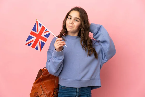 Malá Dívka Drží Vlajku Spojeného Království Izolované Růžovém Pozadí Pochybnostmi — Stock fotografie
