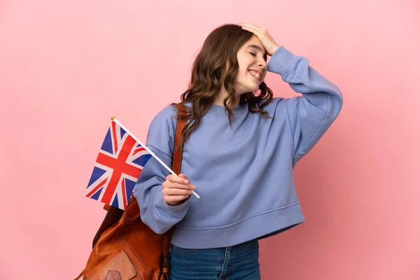 小女孩拿着一面英国国旗 与粉色背景隔离 她意识到了什么 并打算解决这个问题 — 图库照片