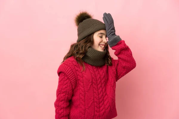 小女孩戴着一顶粉色背景的冬帽 意识到了什么 并打算解决这个问题 — 图库照片