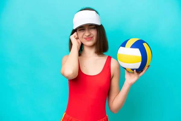 若いですウクライナ人女性遊びバレーボールでビーチに隔離された青の背景不満とカバー耳 — ストック写真