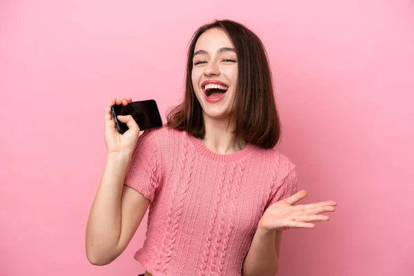 우크라이나 소녀는 핸드폰을 사용하고 노래를 부르며 분홍색 배경으로 고립되어 있었다 — 스톡 사진