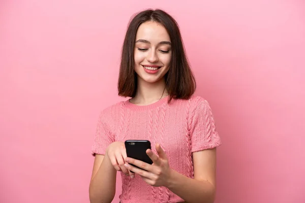 우크라이나 소녀가 분홍색 배경으로 고립되어 휴대폰으로 메시지나 이메일을 보내는 — 스톡 사진