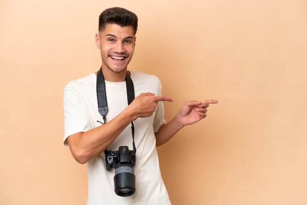 Young Photographer Caucasian Man Isolated Beige Background Pointing Finger Side — Stock Photo, Image