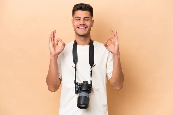 年轻的摄影师高加索男子 因米色背景而被隔离在禅态中 — 图库照片