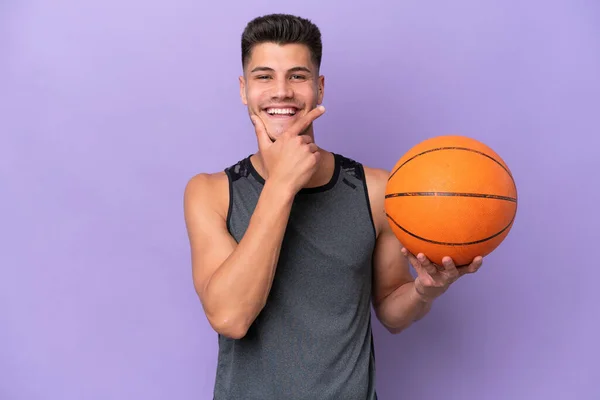 young caucasian woman  basketball player man isolated on purple background happy and smiling