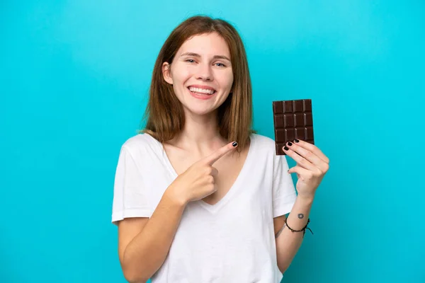 Mladá Anglická Žena Čokoládou Izolované Modrém Pozadí Ukazuje Strany Prezentovat — Stock fotografie