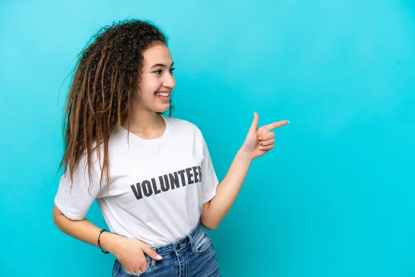 Joven Voluntaria Árabe Aislada Sobre Fondo Azul Señalando Con Dedo — Foto de Stock