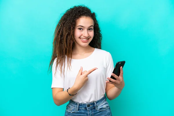 Giovane Donna Araba Isolata Sfondo Blu Utilizzando Telefono Cellulare Indicandolo — Foto Stock
