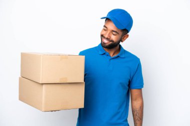 Teslimatçı Brezilyalı adam beyaz arka planda izole edilmiş, yana bakıyor ve gülümsüyor.