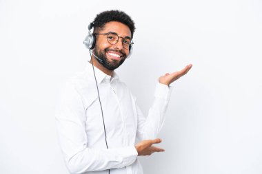 Tele pazarlamacı Brezilyalı adam beyaz arka planda izole edilmiş bir kulaklıkla çalışıyor. Gelmesi için ellerini yana uzatıyor.