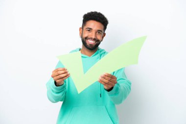 Beyaz arka planda izole edilmiş Brezilyalı genç bir adam elinde mutlu bir ifadeyle bir çek simgesi tutuyor.