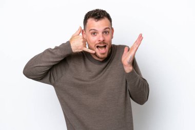 Genç Brezilyalı bir adam beyaz arka planda izole edilmiş telefon jestleri yapıyor.