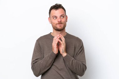 Genç Brezilyalı bir adam beyaz arka planda bir şeyler planlıyor.