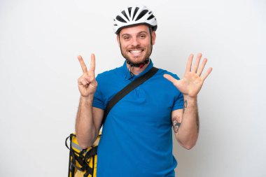 Beyaz arkaplanda izole edilmiş termal sırt çantalı genç Brezilyalı adam parmaklarıyla yediyi saydı.