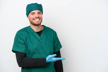 Cerrah Brezilyalı yeşil üniformalı adam beyaz arka planda izole edilmiş gülümserken bir fikir sunuyor.