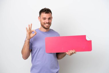 Beyaz arka planda izole edilmiş genç Brezilyalı bir adam boş bir levha tutuyor ve 