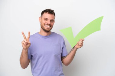 Beyaz arka planda izole edilmiş genç Brezilyalı bir adam elinde bir çek ikonu tutuyor ve zaferi kutluyor.