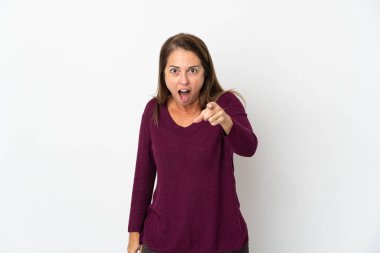 Beyaz arka planda izole edilmiş orta yaşlı Brezilyalı kadın hayal kırıklığına uğramış ve ön tarafı işaret ediyor.