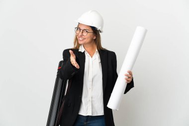 Miğferli orta yaşlı bir mimar, izole edilmiş arka planda planları tutuyor ve iyi bir anlaşma için el sıkışıyor.