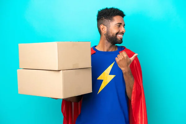 Super Hero Delivery Brazilian Man Isolated Blue Background Pointing Side — Stock Photo, Image