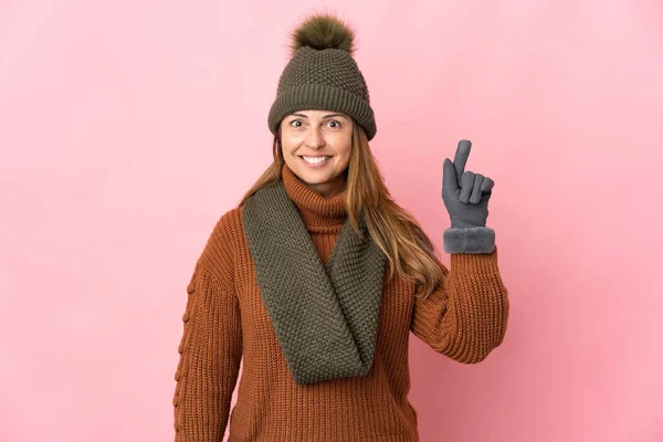 Mulher Meia Idade Com Chapéu Inverno Isolado Fundo Rosa Apontando — Fotografia de Stock