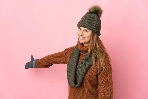 Mulher Meia Idade Com Chapéu Inverno Isolado Fundo Rosa Estendendo — Fotografia de Stock