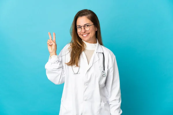 Médica Brasileira Meia Idade Isolada Fundo Azul Sorrindo Mostrando Sinal — Fotografia de Stock