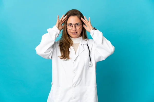 巴西中年妇女医生 因蓝色背景而被隔离 表情惊讶 — 图库照片