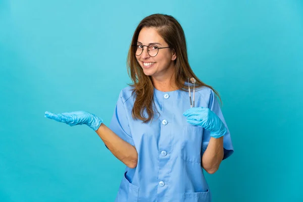 Dentystka Średnim Wieku Brazylijka Trzyma Narzędzia Odosobnionym Tle Wyciągając Ręce — Zdjęcie stockowe