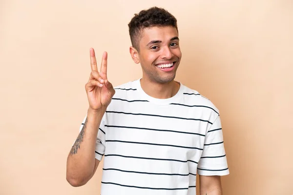 Young Brazilian Man Isolated Beige Background Smiling Showing Victory Sign —  Fotos de Stock