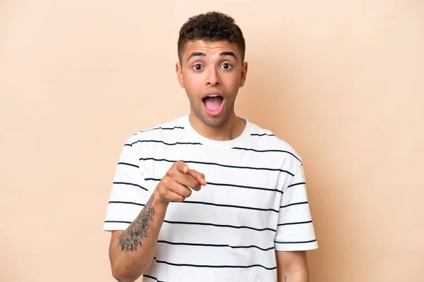 Young Brazilian Man Isolated Beige Background Surprised Pointing Front — ストック写真