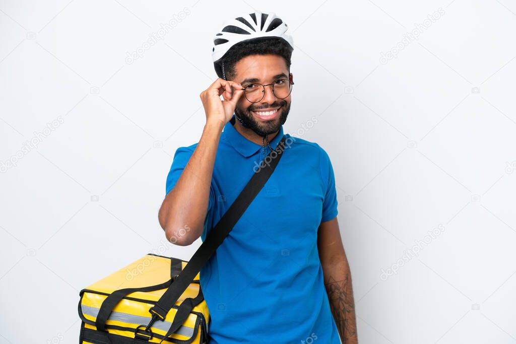 Young Brazilian man with thermal backpack isolated on white background with glasses and happy