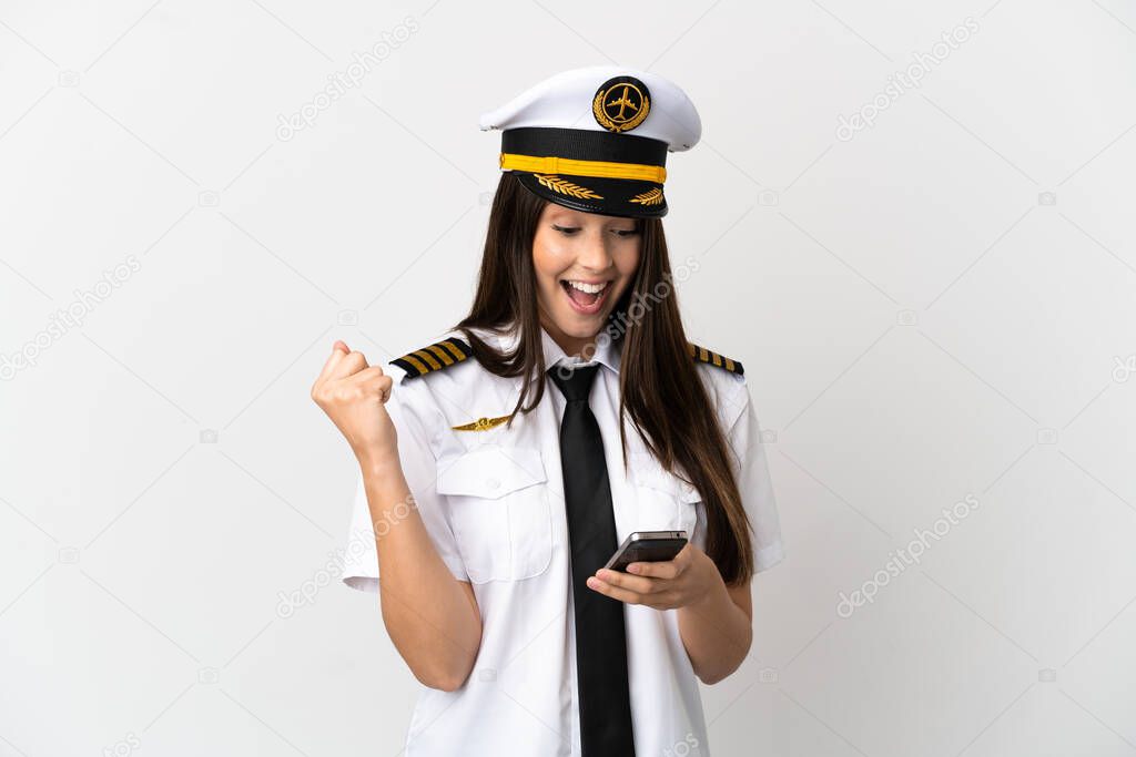Brazilian girl Airplane pilot over isolated white background surprised and sending a message