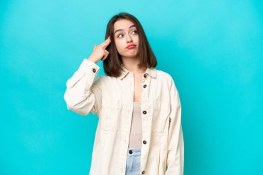 Genç Ukraynalı bir kadın, mavi arka planda intihar jesti yapmada sorun yaşıyor.