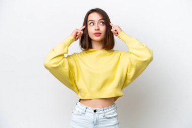 Genç Ukraynalı bir kadın beyaz arka planda izole edilmiş. Şüpheleri ve düşünceleri var.