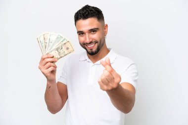 Genç bir Arap beyaz arka planda izole edilmiş bir sürü para alıyor ve para hareketi yapıyor.