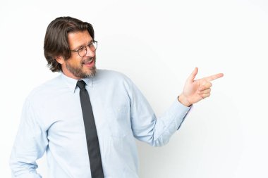 Üst düzey Hollandalı iş adamı beyaz arka planda izole edilmiş bir şekilde parmak işareti yapıyor ve bir ürün sunuyor.