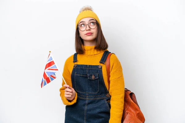 stock image Young Ukrainian woman holding an United Kingdom flag isolated on white background and looking up