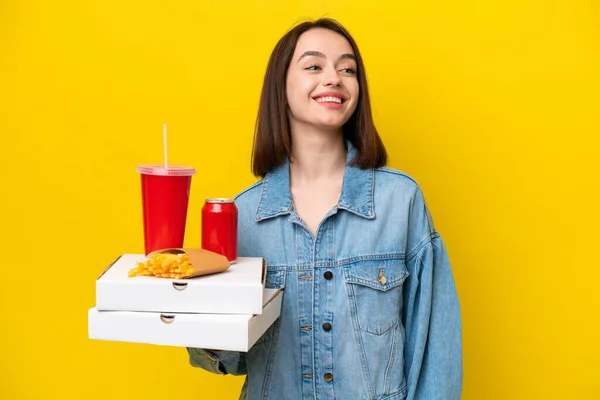 Young Ukrainian Woman Holding Fast Food Isolated Yellow Background Looking — Stock Photo, Image