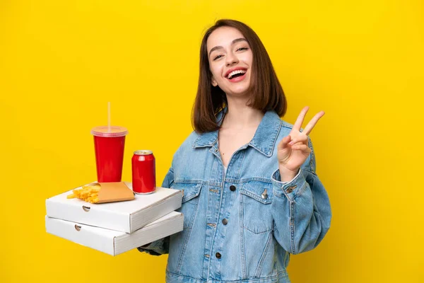 Young Ukrainian Woman Holding Fast Food Isolated Yellow Background Smiling — Stock Photo, Image