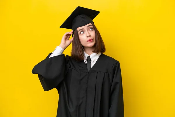 若い大学院生ウクライナ人女性は疑問を持っている黄色の背景に孤立し 顔の表情を混乱させます — ストック写真