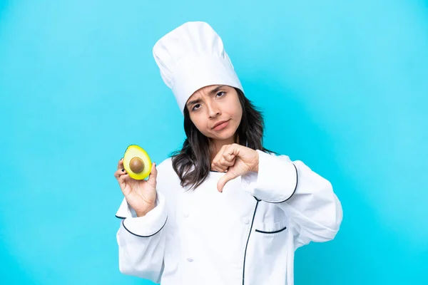 Giovane Chef Ispanica Donna Possesso Avocado Isolato Sfondo Blu Mostrando — Foto Stock