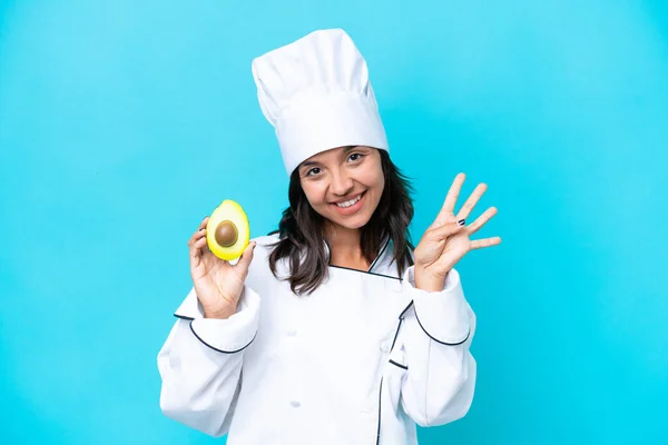 Junge Hispanische Köchin Frau Hält Avocado Isoliert Auf Blauem Hintergrund — Stockfoto