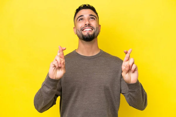 Young Arab Handsome Man Isolated Yellow Background Fingers Crossing Wishing — стоковое фото