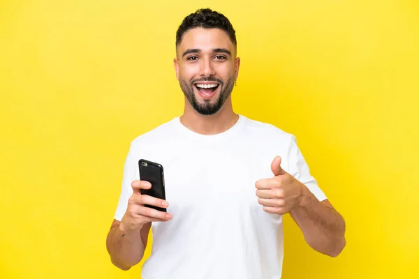 Mladý Arab Hezký Muž Izolované Žlutém Pozadí Pomocí Mobilního Telefonu — Stock fotografie