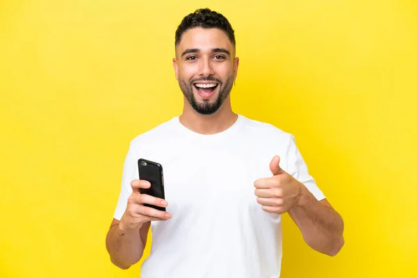 Young Arab Handsome Man Isolated Yellow Background Using Mobile Phone —  Fotos de Stock